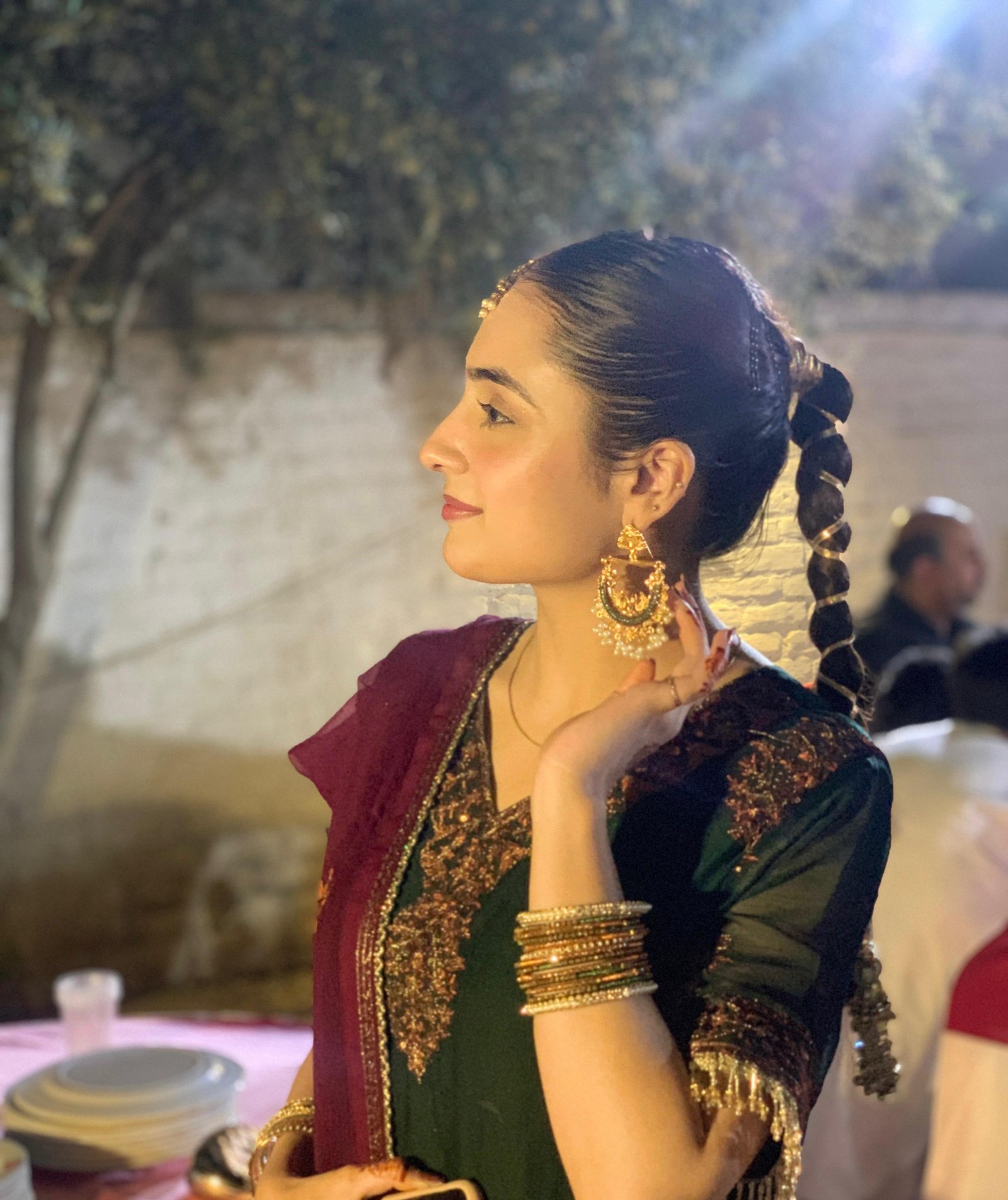 Ayesha wearing gold earrings at an evening celebration